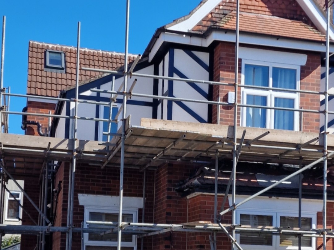 Mock Tudor gable re rendered with smooth white finish and scaffold